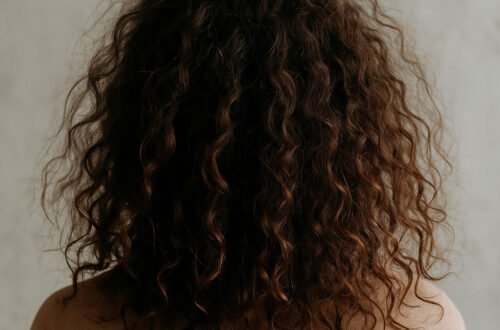 generada por ia Melena rizada con frizz, resequedad y pérdida de definición causada por exceso de proteínas en el cabello, ejemplo de protein overload en el Método Curly