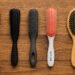 generada por ia Cinco cepillos para rake and shake dispuestos sobre madera, ideales para definir rizos en el Método Curly