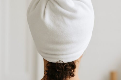 generada por ia Cabello rizado envuelto en toalla blanca con técnica de plopping, ideal para definir rizos sin frizz