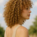 imagen generada por IA mujer con cloud curls en casa, rizos sueltos con volumen y textura esponjosa, fondo natural y luz suave