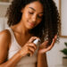 imagen generada por IA mujer aplicando aceite sobre rizos definidos, en rutina LOC para cabello rizado